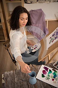 Happy and beatifull female artist drawing the picture at the studio
