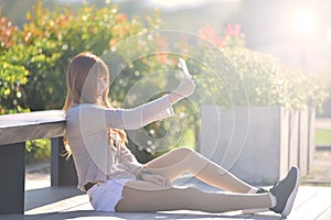 Happy beatuiful asian waman with smartphone sit in garden.