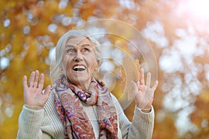 Happy beautifil elderly woman posing in autumn park