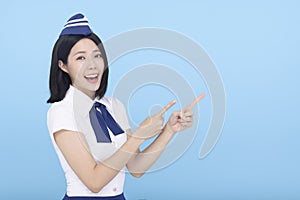 Happy Beautiful Airline stewardess showing something on blue background