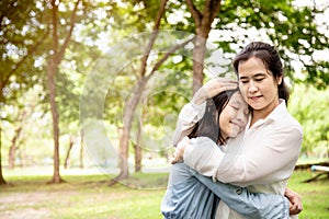 Happy beautiful asian adult woman and cute child girl with hugging and smiling in summer,love of mother with her little daughter