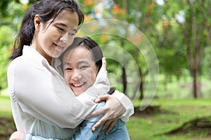 Happy beautiful asian adult woman and cute child girl with hugging and smiling in summer,love of mother with her little daughter