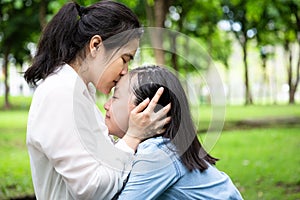 Happy beautiful asian adult woman and cute child girl with hugging,kissing and smiling in summer,love of mother with her little