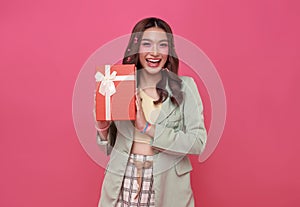 Happy beautiful Asian teen woman smile with red gift box isolated on pink background. Teenage girls in love, Receiving gifts from