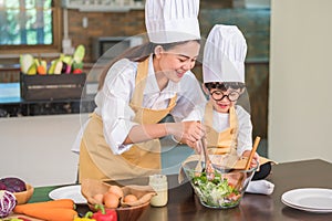 Happy beautiful Asian woman and cute little boy with eyeglasses prepare to cooking in kitchen at home. People lifestyles and