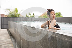 Happy beautiful asian woman enjoying time on the pool