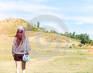 Happy Beautiful Asian Woman with Hat and Bag Ready to Start Vacation at The Corner with Scenery Mountain in Background