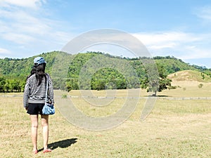 Happy Beautiful Asian Woman with Hat and Bag Ready to Start Vacation at The Corner with Scenery Mountain in Background