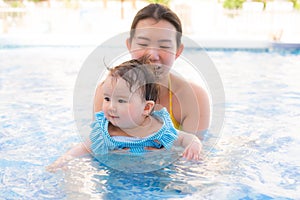 happy and beautiful Asian woman holding her little baby girl playful - Korean mother and adorable daughter playing on water at