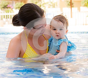 happy and beautiful Asian woman holding her little baby girl playful - Korean mother and adorable daughter playing on water at