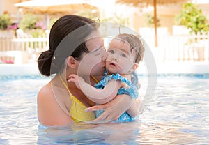 happy and beautiful Asian woman holding her little baby girl playful - Korean mother and adorable daughter playing on water at