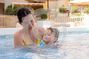 happy and beautiful Asian woman holding her little baby girl playful - Korean mother and adorable daughter playing on water at