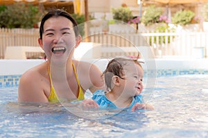 happy and beautiful Asian woman holding her little baby girl playful - Korean mother and adorable daughter playing on water at