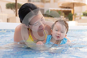 happy and beautiful Asian woman holding her little baby girl playful - Korean mother and adorable daughter playing on water at