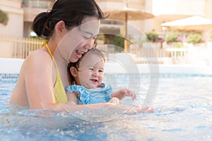 happy and beautiful Asian woman holding her little baby girl playful - Korean mother and adorable daughter playing on water at