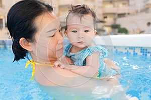 happy and beautiful Asian woman holding her little baby girl playful - Korean mother and adorable daughter playing on water at