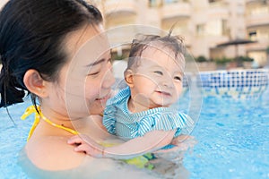 happy and beautiful Asian woman holding her little baby girl playful - Korean mother and adorable daughter playing on water at