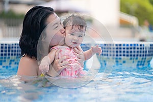 happy and beautiful Asian woman holding her little baby girl playful - Korean mother and adorable daughter playing on water at