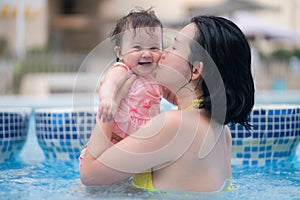 happy and beautiful Asian woman holding her little baby girl playful - Korean mother and adorable daughter playing on water at