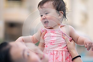 happy and beautiful Asian woman holding her little baby girl playful - Korean mother and adorable daughter playing on water at