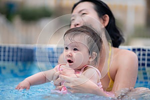 happy and beautiful Asian woman holding her little baby girl playful - Korean mother and adorable daughter playing on water at