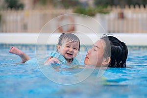 happy and beautiful Asian woman holding her little baby girl playful - Korean mother and adorable daughter playing on water at