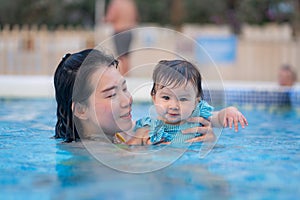 happy and beautiful Asian woman holding her little baby girl playful - Korean mother and adorable daughter playing on water at