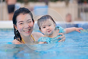 happy and beautiful Asian woman holding her little baby girl playful - Korean mother and adorable daughter playing on water at