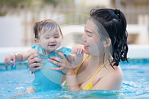 happy and beautiful Asian woman holding her little baby girl playful - Korean mother and adorable daughter playing on water at