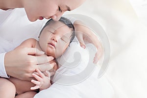 Happy beautiful asian woman looking at her sleeping baby child