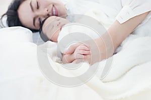 Happy beautiful asian woman looking at her sleeping baby child