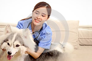 Happy beautiful Asian woman veterinarian examining dog at clinic, young vet woman doctor with stethoscope working with pet,