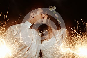 Happy beautiful bride and elegant stylish groom holding firework photo