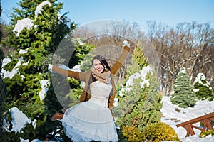 Happy beautiful bride in a snowy winter day. Sunny weather. stylish. with the wedding bouquet made from pine-tree hand made. mitte