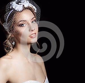 Happy beautiful bride woman blonde girl in a white wedding dress, with hair and bright make-up with veil in her eyes and flowers