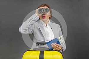 Happy beautiful business woman looking through binoculars towards her travels