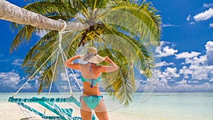 Happy beautiful carefree woman enjoying sunshine on the beach. Young woman in red pink bikini in white sandy beach at Maldive