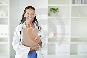 Happy beautiful caucasian mature woman doctor at clinic, copy space