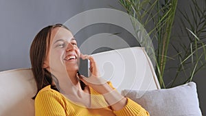 Happy beautiful Caucasian woman involved in pleasant smartphone call conversation with friends sharing discussing life news,