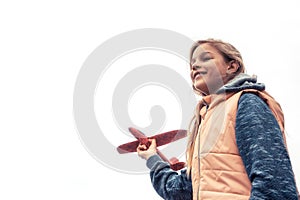 Happy beautiful child girl with toy airplane on white sky background looking with inspiration concept for start career