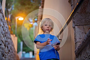 Happy beautiful children, playing on stone stairs in old town, taking pictures