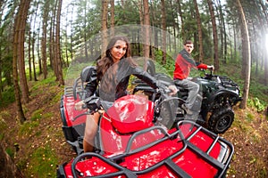 Happy beautiful couple driving four-wheelers ATV