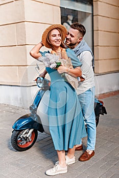 Happy beautiful couple on scooter in european city