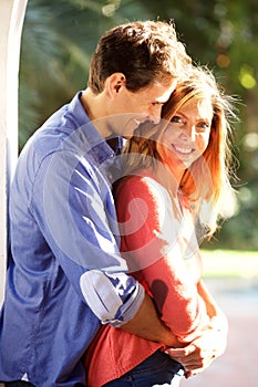 Happy beautiful couple standing outside in embrace