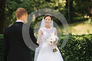 Happy beautiful couple walking in the park in their wedding day. Just married