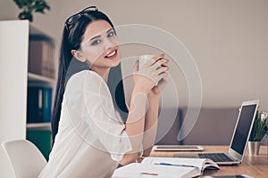 Happy beautiful cute young relaxed businesswoman sitting at the photo