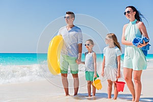 Happy beautiful family on a tropical beach vacation going to swim
