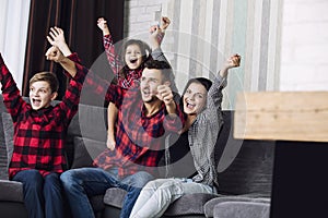 Happy beautiful fashion family fun together at home in living room smiling sitting on sofa portrait