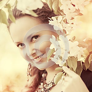 Happy beautiful fashion woman in a spring blooming garden