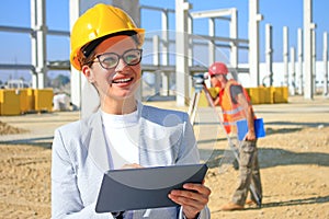 Female architect with tablet and construction engineer